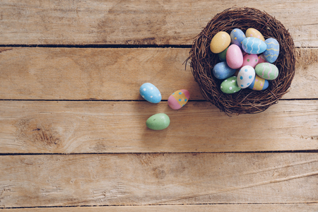 Colorful Easter egg and nest on wooden table background with copy space.の写真素材