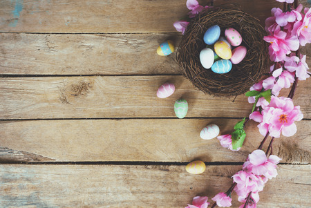 Cherry blossom Artificial flowers and easter egg in nest on vintage wooden background with copy space.の写真素材