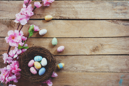 Cherry blossom Artificial flowers and easter egg in nest on vintage wooden background with copy space.の写真素材