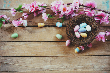 Cherry blossom Artificial flowers and easter egg in nest on vintage wooden background with copy space.の写真素材