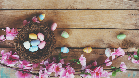 Cherry blossom Artificial flowers and easter egg in nest on vintage wooden background with copy space.の写真素材