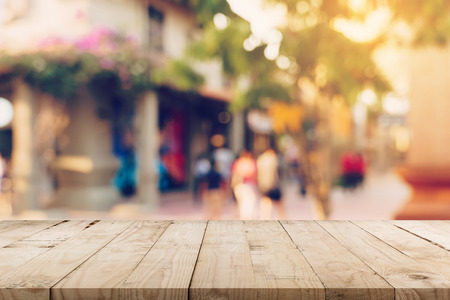 Empty wood table and Vintage tone blurred defocused of crowd people in walking street festival and shopping mall.の写真素材