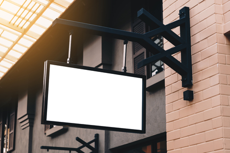 Empty signage and blank mock up hanging on street with copy spaceの写真素材