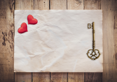 Old key and red heart on Old paper vintage on wood background with spaceの写真素材