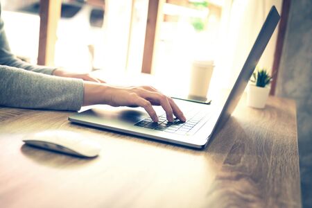 asian woman using laptop computer do online activity on wood table at home office.の写真素材