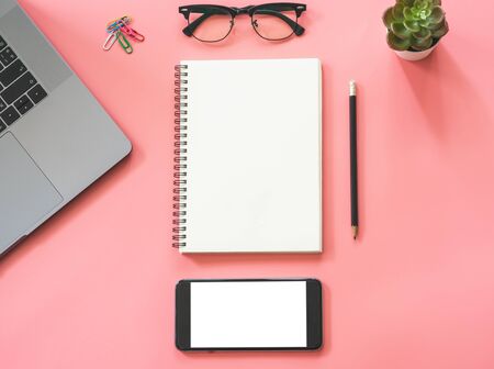 Flat lay design of workspace desk with laptop, blank notebook, smartphone, pencil, stationery with copy space backgroundの写真素材