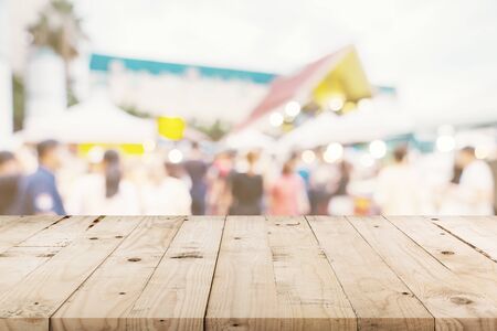 Empty wood table and Vintage tone blurred defocused of crowd people in walking street festival and shopping mall.の写真素材