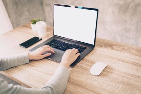 Asian woman using computer laptop for working on wooden tableの写真素材