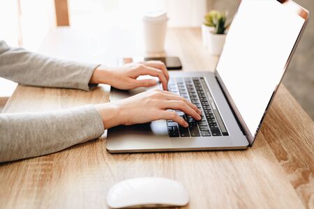 Asian woman using computer laptop for working on wooden tableの写真素材