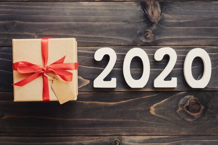 2020 New year concept : 2020 wood number and brown gift box on wood table background.の写真素材