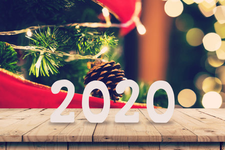 2020 New year concept on Empty wood table and christmas pine cones hanging from Christmas tree with...