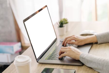Business woman hand typing laptop computer on wooden tableの写真素材