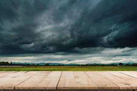 Natural scenic beautiful field storm clouds  and Empty wood table for product display and montage.の写真素材