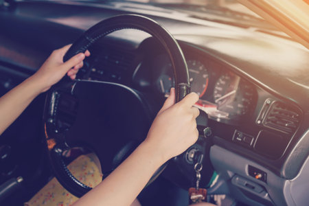 woman driver hands holding steering wheel driving a car