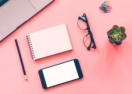Flat lay design of workspace desk with laptop, blank notebook, smartphone, pencil, stationery with copy space backgroundの写真素材