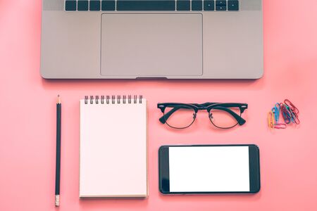 Flat lay design of workspace desk with laptop, blank notebook, smartphone, pencil, stationery with copy space backgroundの写真素材