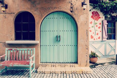Old door and wooden chair front of houseの写真素材