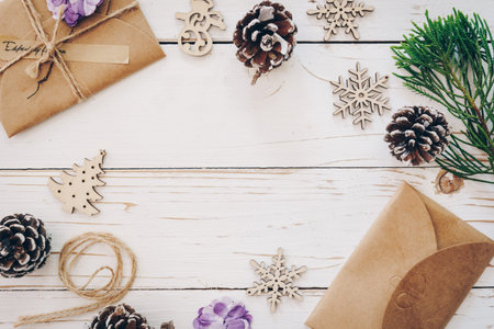 Top view of gift box and christmas card on wooden table with xmas decoration.