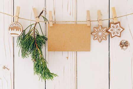 Close up of christmas decoration and blank paper card hanging on wood background.の写真素材