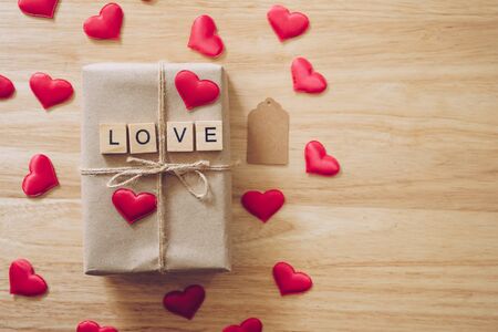 Top view brown gift box and red heart on wood background for valentine day with copy space.の写真素材