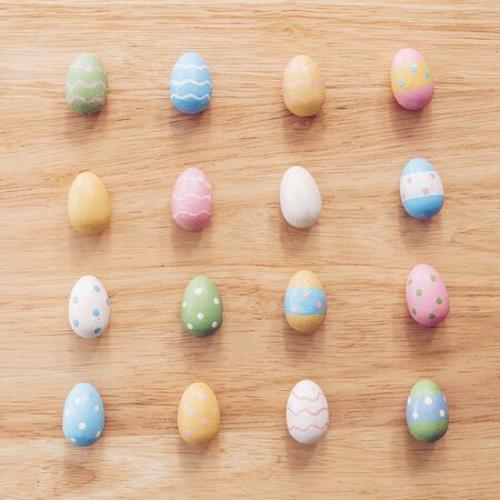 Colorful easter eggs on wooden table background with vintage toned.の写真素材