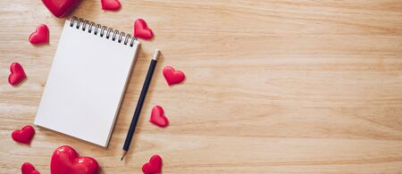 panorama shot of top view notepad and red heart on wood background for valentine day with copy space.の写真素材