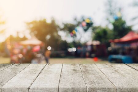 Empty wood table and defocused bokeh and blur background of garden trees in sunlight, display montage for product.の写真素材