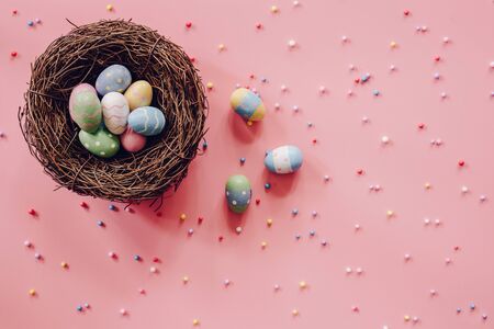 Pastel Easter eggs on pink background top view with natural light. Flat lay style.の写真素材
