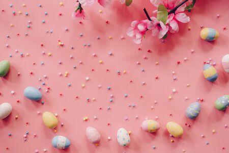 Pastel Easter eggs on pink background top view with natural light. Flat lay style.の写真素材
