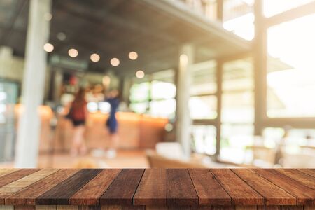 Empty wood table and Blurred background : Customer at coffee shop blur background with bokeh, display montage for product.の写真素材
