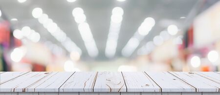 Empty wood table and blurred light table in shopping mall with bokeh background. product display template.の写真素材