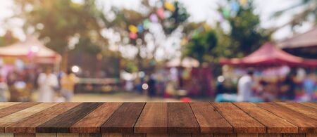 Empty wood table and defocused bokeh and blur background of garden trees in sunlight, display montage for product.の写真素材