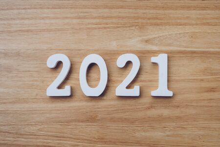 Business and design concept - wooden number 2021 for Happy new year text on wood table.の写真素材