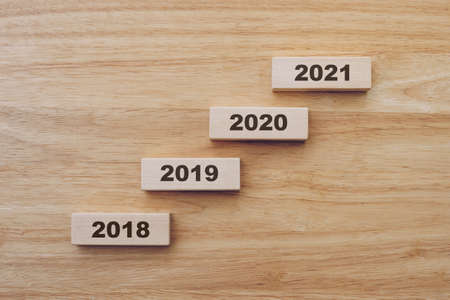2018 to 2020 happy new year on wood block on wood table background. new year conceptの写真素材