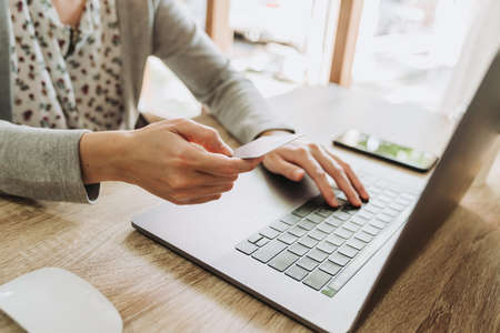 Woman hand holding credit card and using laptop for shopping onlineの写真素材