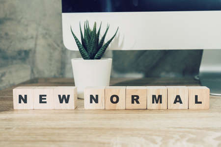 New Normal on wood block on wood table desktop computer and pot plant.の写真素材