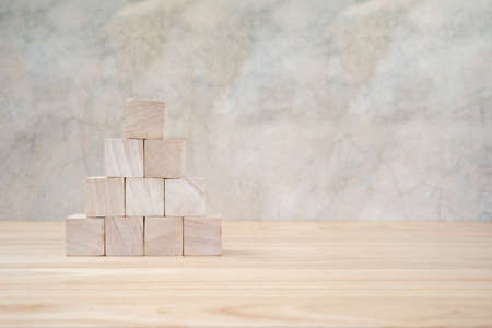 Wooden toy cubes on wooden table ang grey backgroundの写真素材