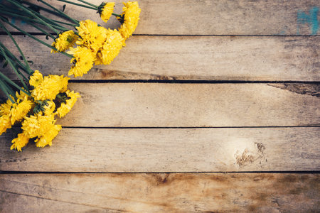 Yellow flowers of bouquet, top view on wooden background texture with copy spaceの写真素材
