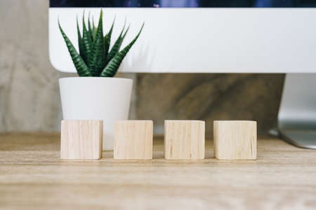 Four wooden toy cubes on wooden table background with copy spaceの写真素材