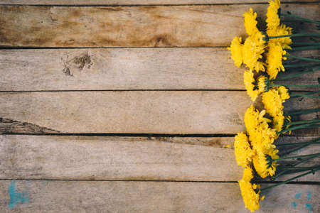 Yellow flowers of bouquet, top view on wooden background texture with copy spaceの写真素材