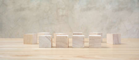 Wooden toy cubes on wooden table ang grey backgroundの写真素材