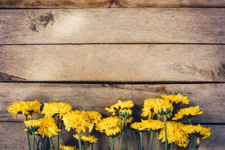 Yellow flowers of bouquet, top view on wooden background texture with copy spaceの写真素材