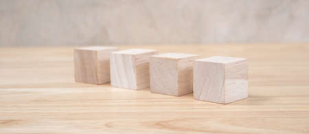 Wooden toy cubes on wooden table ang grey backgroundの写真素材