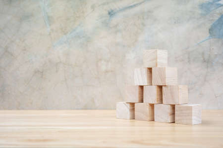 Wooden toy cubes on wooden table ang grey backgroundの写真素材