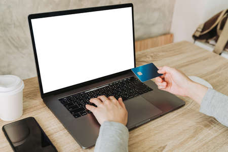 Woman hand holding credit card and using laptop for shopping onlineの写真素材