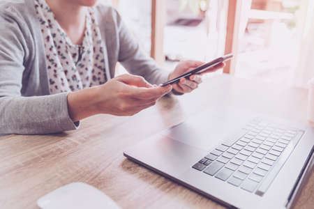 woman using smart phone and credit card for shopping online in coffee shopの写真素材