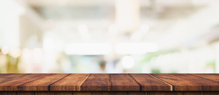 Empty wood table and blurred light table in shopping mall with bokeh background. product display...