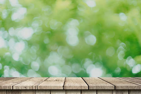 Empty wood table and green bokeh blur with copy space display montage for product.の写真素材
