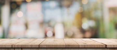 Empty wood table and blurred light table in coffee shop and cafe with bokeh background. product display template.の写真素材