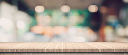 Empty wood table and blurred light table in coffee shop and cafe with bokeh background. product display template.の写真素材
